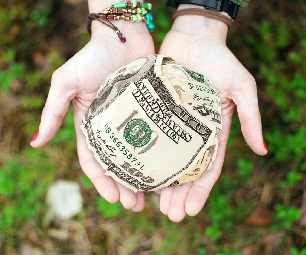 pexels-photo-271168-271168 Hands holding crumpled money outdoors, symbolizing charity and financial support.