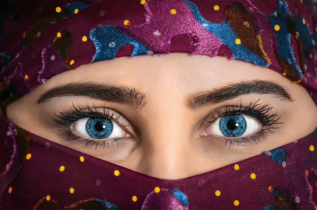 pexels-photo-413998-413998 Close-up portrait of a woman with striking eyes and a colorful patterned headscarf.