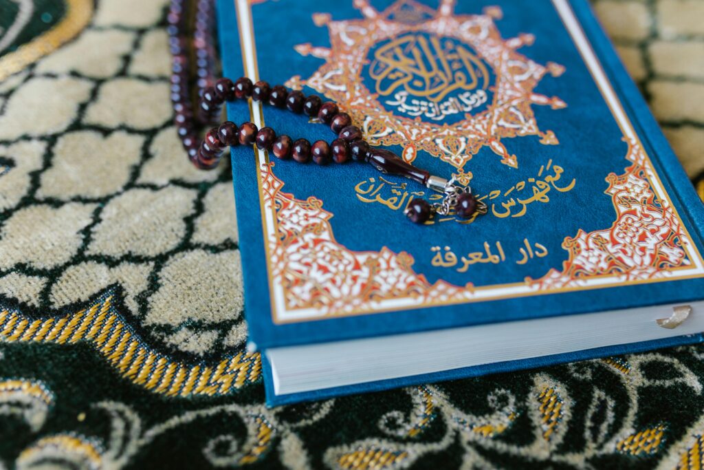 pexels-photo-7249183-7249183 A Quran with prayer beads on a decorative carpet, symbolizing Islamic spirituality.