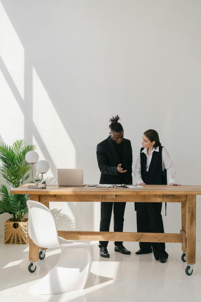 pexels-photo-7679562-7679562 Two professionals engaged in discussion at a sleek office space, showcasing modern business collaboration.