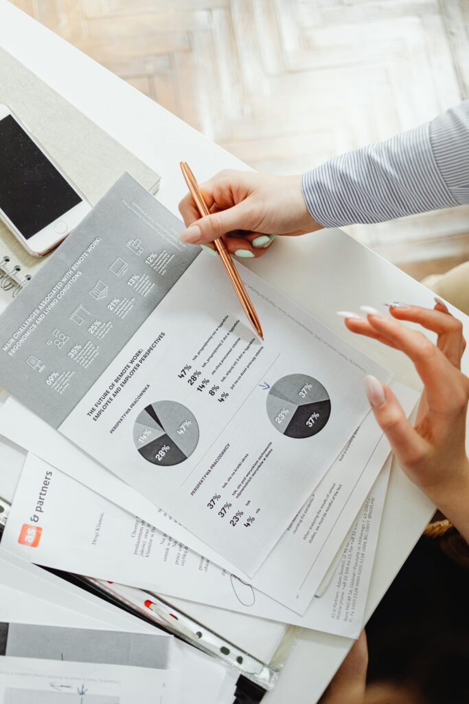 pexels-photo-7681097-7681097 Close-up of businesswoman analyzing financial reports using pie charts in an office setting.