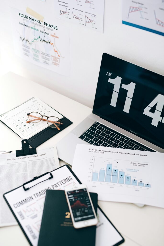 pexels-photo-7887849-7887849 A neat desk setup with a laptop, phone, and financial documents, highlighting digital currency trends.