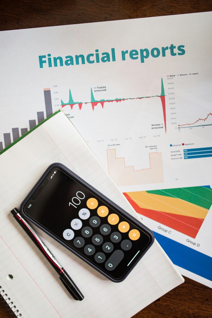 pexels-photo-7947637-7947637 Top view of financial reports with a calculator app open on a smartphone.