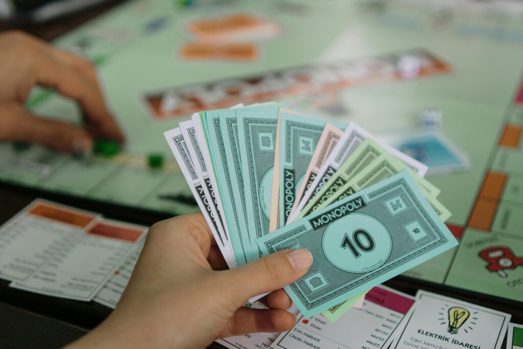 A close-up view of a person holding Monopoly money while playing the board game.