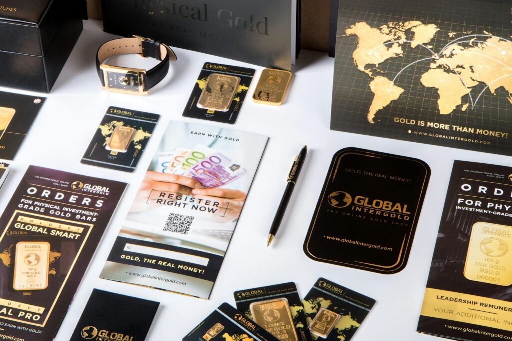 pexels-photo-342943-342943 Flat lay of promotional materials for gold investment, featuring brochures, cards, and gold bars.