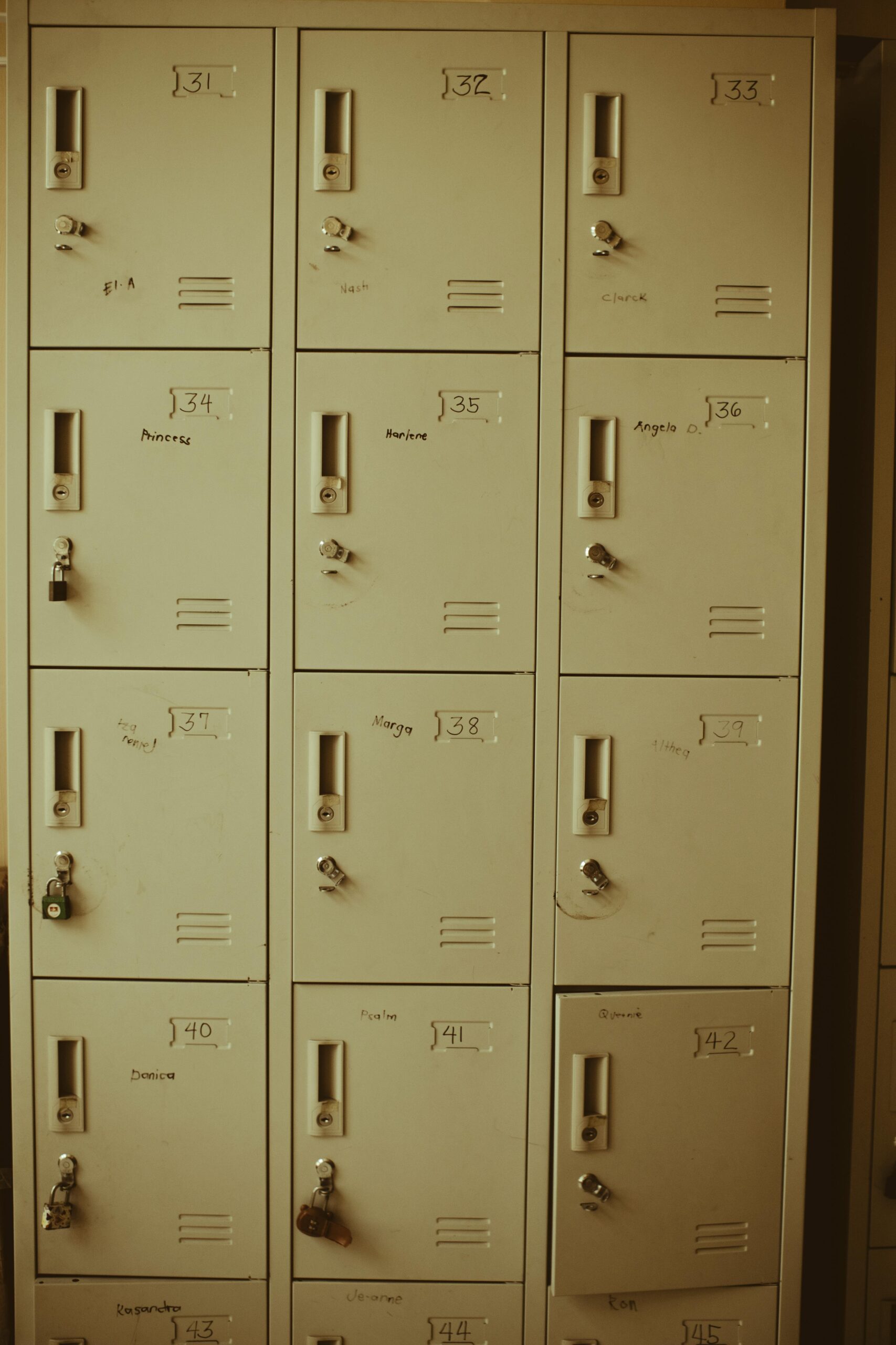 Vertical shot of metal lockers with locks in a school corridor, emphasizing safety and organization.