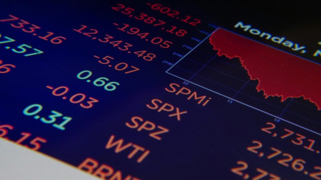 pexels-photo-7054384-7054384 Close-up of a digital stock market graph showing falling trends and financial indices in red and green.