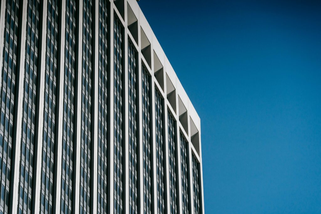 pexels-photo-7078652-7078652 Low angle facade of contemporary multistory skyscraper with many windows against blue sky