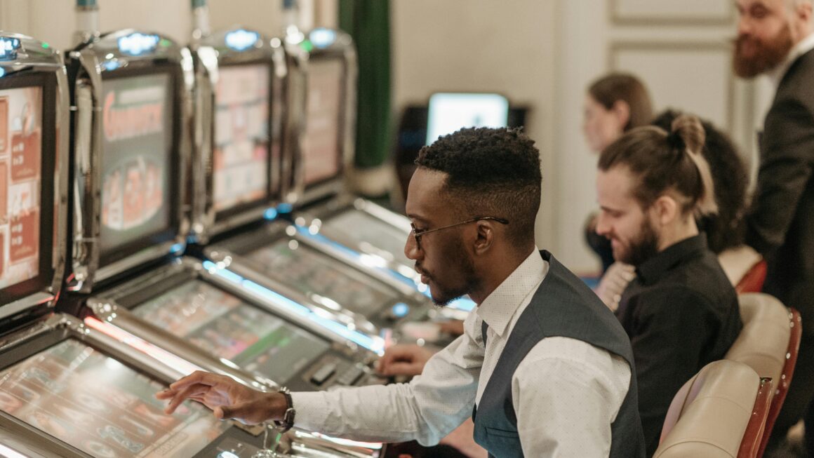 Group of men enjoying an evening at a casino, playing slot machines indoors.