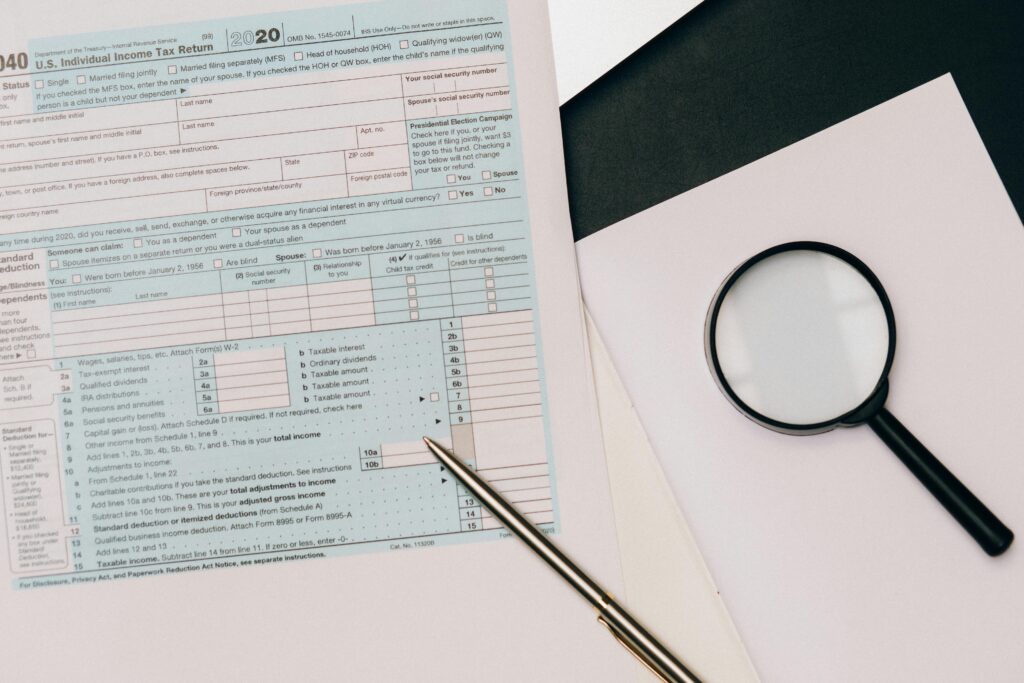 pexels-photo-8927451-8927451 A detailed view of a tax return form with a pen and magnifying glass, perfect for financial themes.