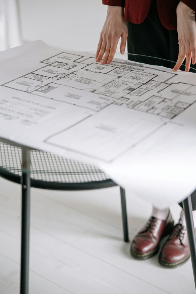pexels-photo-8962797-8962797 Person examining a detailed architectural floor plan on a table indoors with a focus on design.